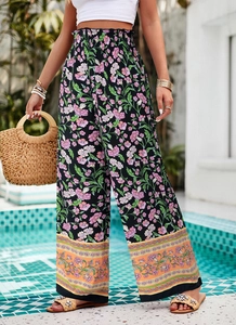 Détail de pantalon large à fleurs taille haute avec bordure orange au bord de la piscine