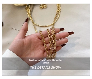 Detail of the golden metal chain strap with oval links and decorative metallic beads
