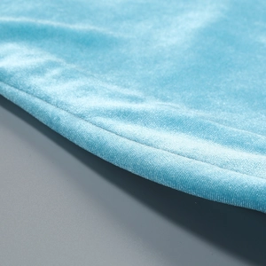 Gros plan sur la texture du velours bleu et les coutures de précision de la robe