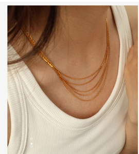 Detail view of multi-layered gold snake chain necklace on model with layered design