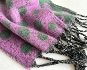 Detail of pink cashmere-like scarf with green polka dots and black fringe texture