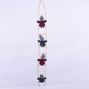Detail of wool felt gnomes climbing on a wooden hemp rope ladder for Christmas decor