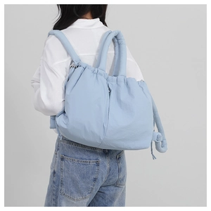 Rear view of a light blue nylon drawstring backpack with padded puff design and top handles