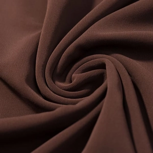 Gros plan détaillé du tissu en maille marron foncé montrant sa texture douce