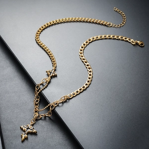 Close-up of gold titanium cuban chain necklace with a layered cross pendant and lobster clasp