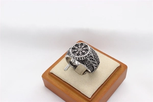 Close-up of vintage silver Viking compass ring with Nordic runes and textured details