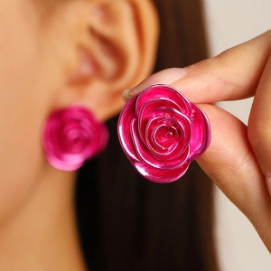 Detailed view of fuchsia rose earrings with metallic finish and layered floral petals