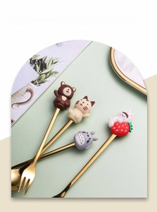 Detail showing golden stainless steel spoons and forks with cute 3D cartoon animal handles