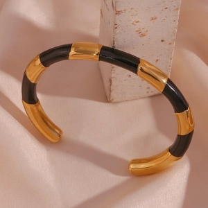 Detail of 18K gold plated stainless steel bamboo segment bracelet with black enamel
