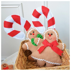 Detail of plush gingerbread man dolls with candy cane headbands in a woven basket