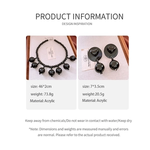 Detailed view of black acrylic beaded necklace and heart-shaped drop earrings set