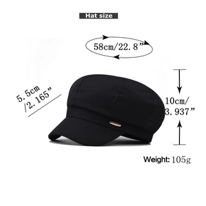 Detail view of black newsboy cap with gold metal logo and precise size measurements