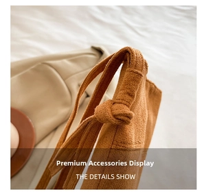 Detail of brown suede shoulder strap with handcrafted knot design and fine stitching