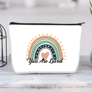 Detail of white canvas makeup bag featuring a rainbow print and You Are Loved text
