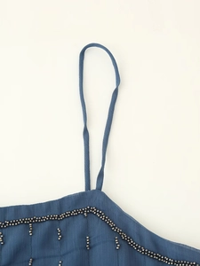 Detail of blue chiffon camisole showing delicate beadwork and slim shoulder strap