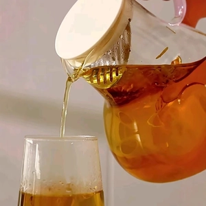 Clear heart-shaped glass pitcher with filter lid pouring water in a dynamic splash