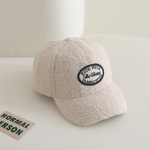 Detailed view of beige faux shearling baseball cap with vintage classic style patch