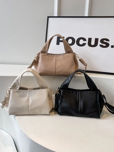 Minimalist faux leather crossbody handbags in beige, cream and black on display