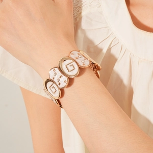 Détail macro du bracelet plaqué or avec émail blanc, motifs d'étoiles et strass incrustés