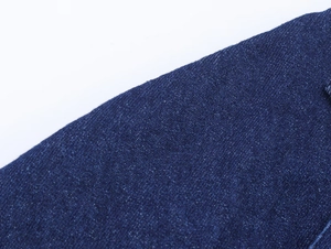 Detailed macro view of high-quality dark blue denim fabric with twill weave texture