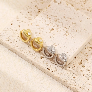Detailed view of gold and silver heart-shaped hoop earrings with central crystal stone