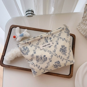 Detail of the blue floral print on the canvas cotton makeup bag with a zipper closure