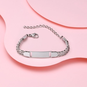 Macro detail of polished stainless steel mesh bracelet with engravable blank plate charm