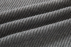 Dettaglio macro del tessuto a maglia a coste grigio scuro con trama e motivi soffici
