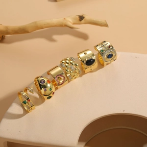 Artistic close-up of 14K gold plated vintage rings set with zircon on stone display