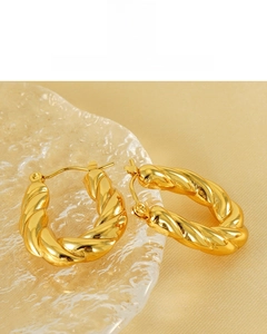 Detailed close-up of 18K gold-plated twisted hoop earrings with a shiny polished finish