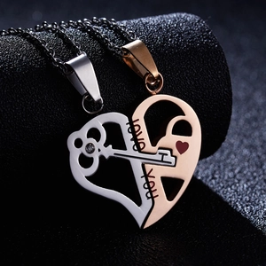 Macro shot of silver key and rose gold lock puzzle heart pendants with I love you engraving