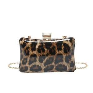 Detail of glossy leopard print clutch with gold metal clasp and chain strap