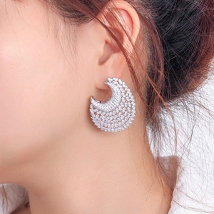 Elegant crescent moon-shaped hoop earrings with sparkling cubic zirconia on female model