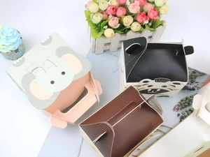 Detail of cartoon animal gift boxes with handles and elephant or zebra patterns