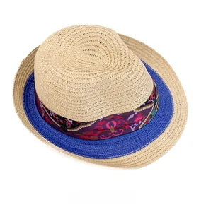 Top view of beige straw sun hat with ethnic purple floral ribbon and blue accent cord