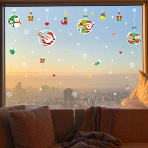 Christmas window stickers with Santa and reindeer on glass against a sunset city view