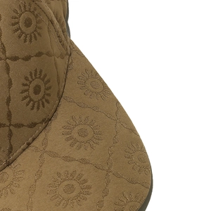 Vue détaillée de la texture tissée et du motif tournesol d'une casquette marron