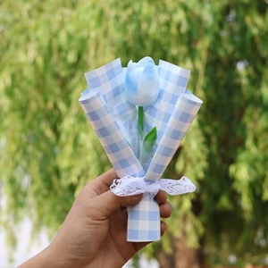 Close-up of a blue artificial tulip bouquet with checkered wrap and white lace ribbon