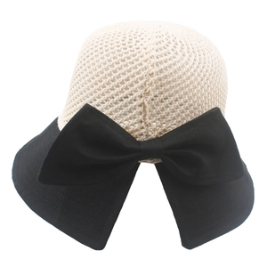 Close-up of beige hollow weave texture and large black bow on summer sun hat