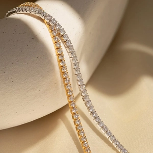 Close-up of gold and silver tennis bracelets with sparkling round-cut cubic zirconia