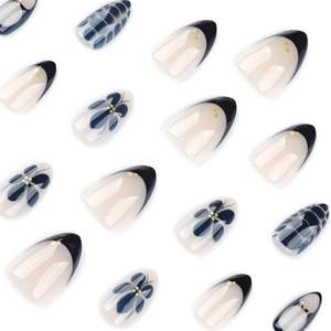 Short almond press-on nails featuring blue floral patterns and black French tips