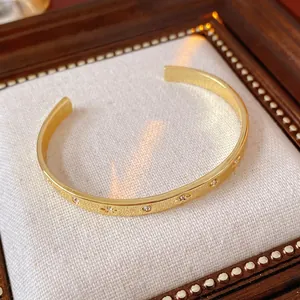 Bracelet jonc ouvert plaqué or avec zircons cubiques et sertissage en forme d'étoile