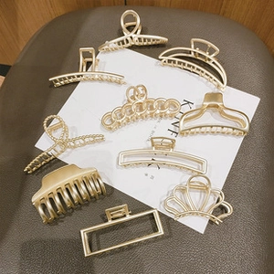 Detailed view of assorted matte gold metal hair clips in various geometric shapes