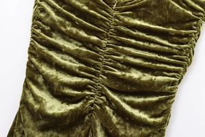 Detail view of olive green velvet fabric with ruching and hidden zipper closure