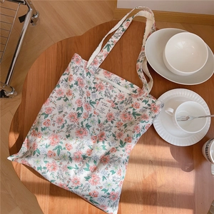 Sac fourre-tout à fleurs sur table en bois avec bols et ombres naturelles