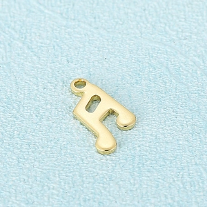 Pendentif note de musique en acier inoxydable doré poli sur un fond bleu texturé