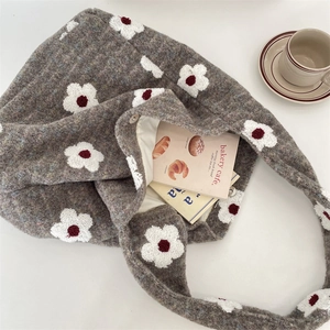 Dettaglio dell'interno della borsa tote in peluche grigio con motivo floreale e fodera