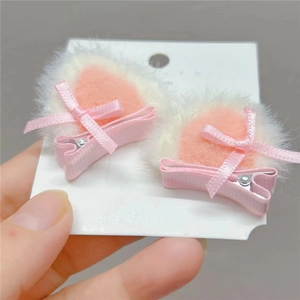 Detail of plush cat ear hair clips with pink ribbons and silver metal alligator clips