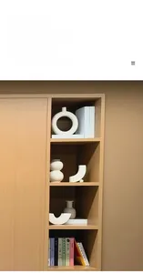 Détail de vases en céramique blanche mate aux formes géométriques sur étagère en bois