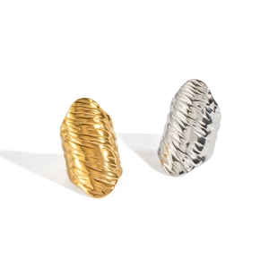 Detailed view of textured metal rings featuring irregular ripples in gold and silver finish